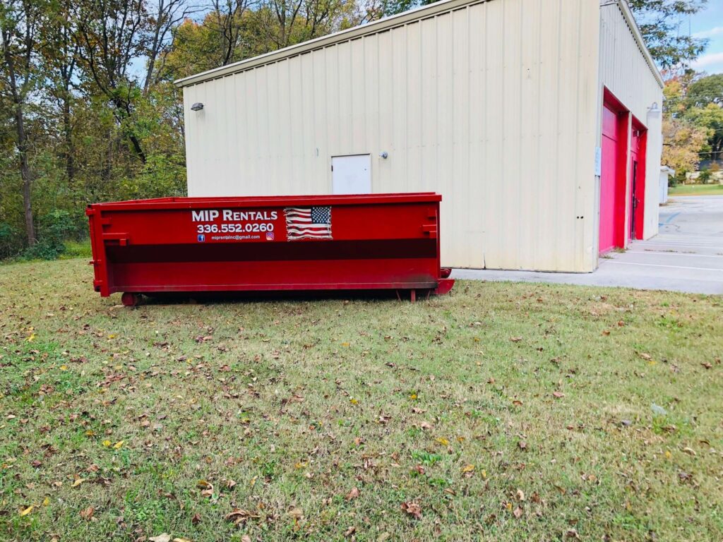 a dumspter in the side of garage Dumpster Rental