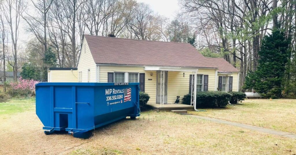 A large dumpster placed in a residential driveway for home cleanup — perfect for Home Dumpster Rental Stokes County residents rely on.