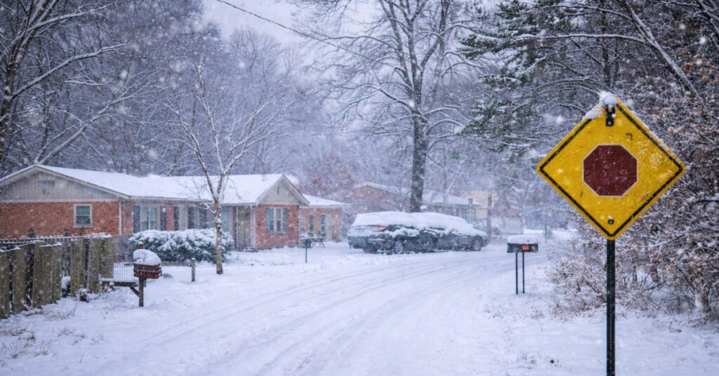 Snowstorm Safety Tips for North Carolina: A quiet neighborhood covered in heavy snow during a winter storm, showing icy roads and low visibility that highlight the importance of winter safety.